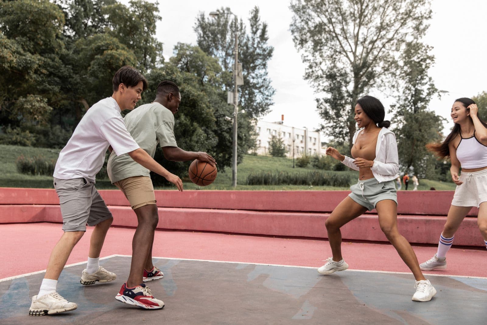 Friends playing basketball together on an outdoor park court