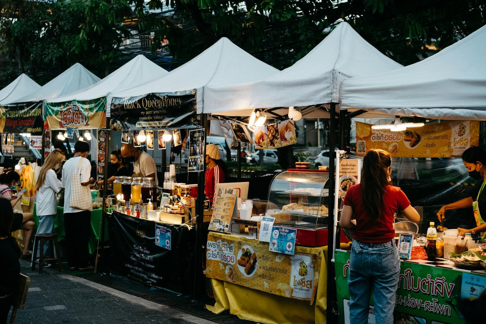 Food and craft stalls at a busy outdoor street market.