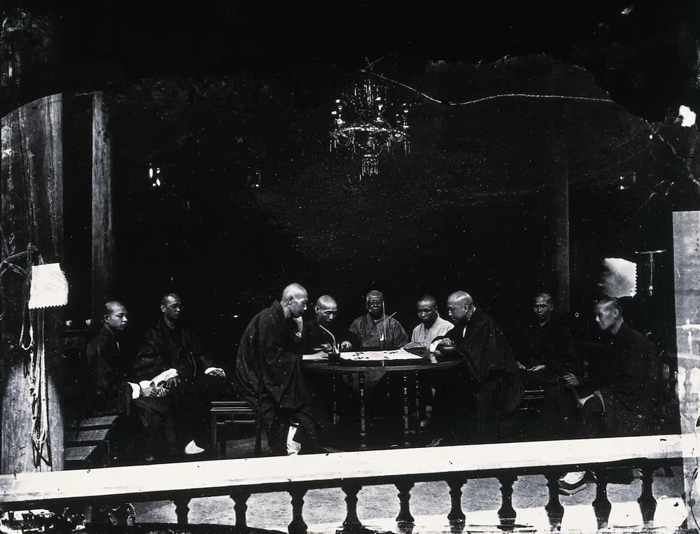 Historical photograph of Buddhist monks gathered around a board game in Guangzhou