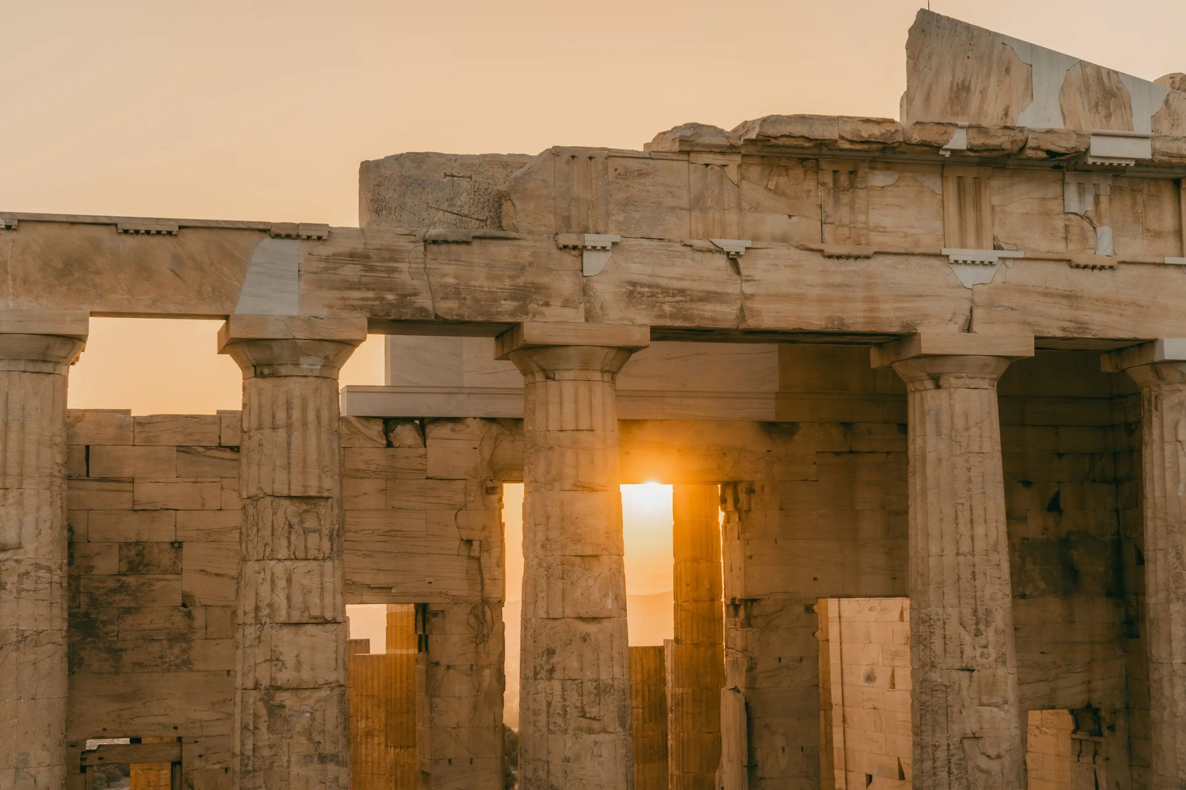 The columns of the Parthenon at sunset, the sun showing between them