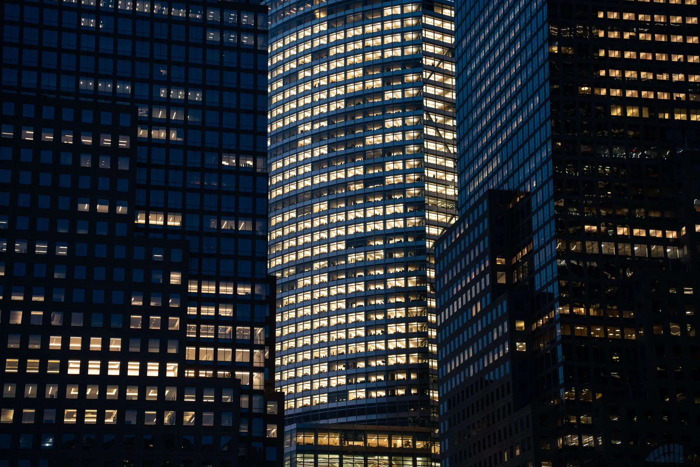 Office towers at night, hundreds of windows lit