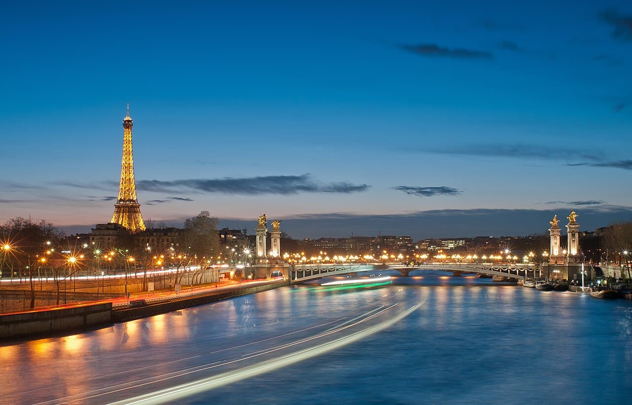 La tour Eiffel et le pont Alexandre III illuminés au-dessus de la Seine à Paris.