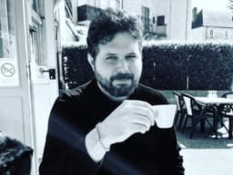 Christophe Porot holding a cup at a café