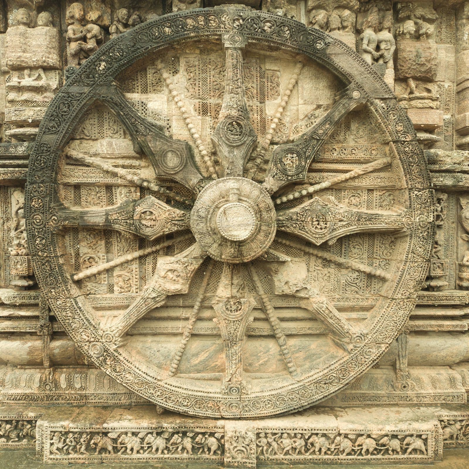 Intricately carved stone chariot wheel of the Konark Sun Temple, spokes and rim covered in relief work.